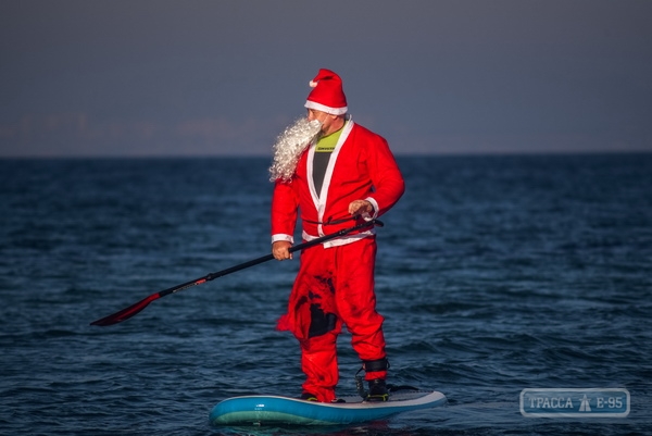 Санта-Клаус проплыл на доске для серфинга вдоль пляжа в Одессе (фото)