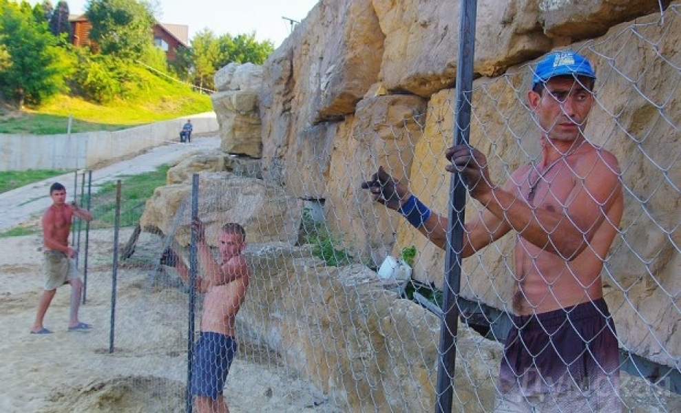 Рабочие ставят новый забор на пляже олигарха в Одессе (фото)