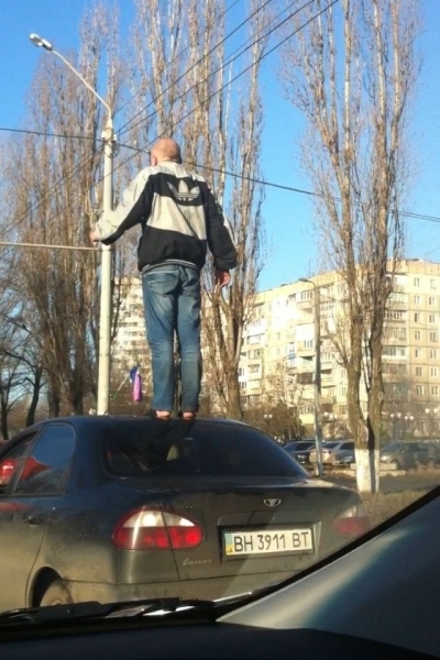 Босоногий мужчина проехал по Одессе, стоя на крыше автомобиля 