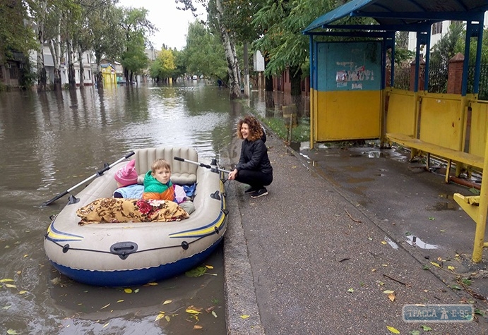 Одесситка с двумя детьми поплыла в магазин на лодке по затопленной Пересыпи (фото)