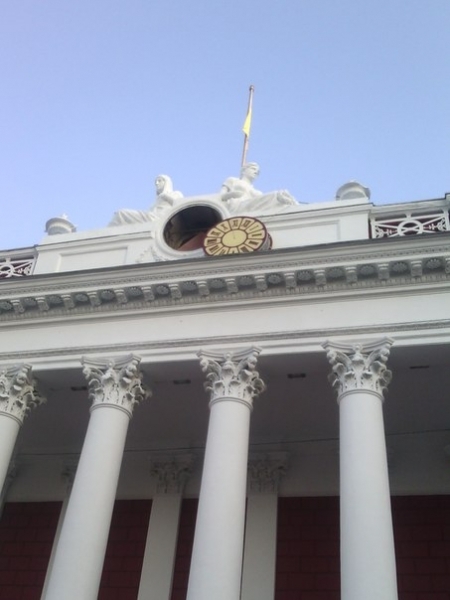 Рабочие меняют часы на здании мэрии в Одессе